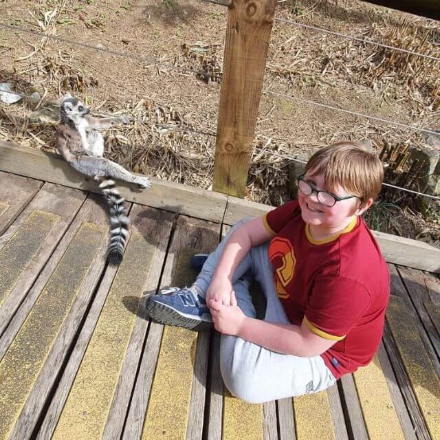 Amy's son, Leon sitting next to a ring-tailed lemur.