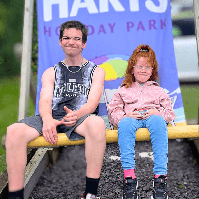 A photo of Tania's son and daughter sitting on a huge chair in holiday park.