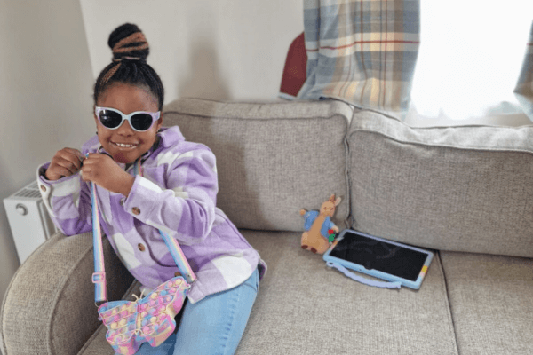A photo of Kate's granddaughter, Kayla wearing sunglasses sitting on the couch.