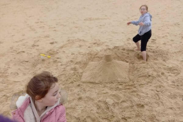 Eden and Kay built a sandcastle in the beach.