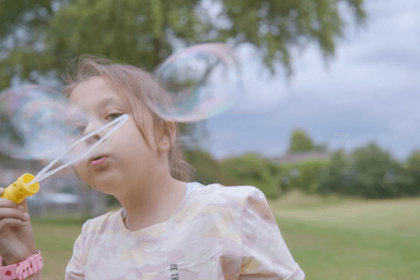 Pinkie's daughter, Leah blowing bubbles in the park.