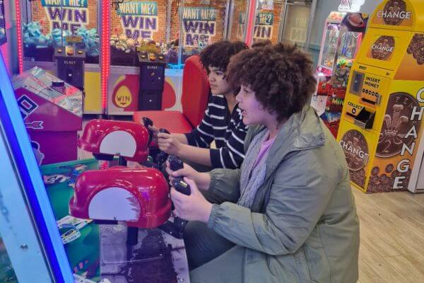 Stacy's two sons playing games in an arcade.