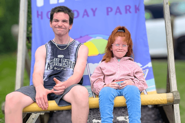 Tania's son and daughter sitting on a huge chair in the holiday park.