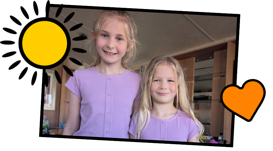 Two young girls wearing purple smiling 