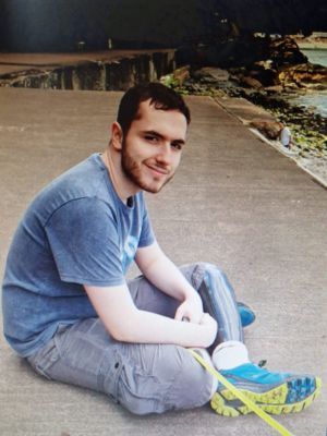 Mandy's son Logan, smiling sat on the beach