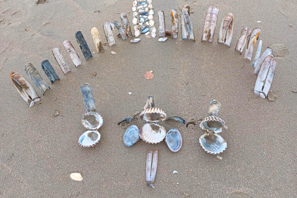 A pattern of shells on the sand that Lucy and Maria played with on the beach during their holiday to Parkdean with Family Holiday Charity.