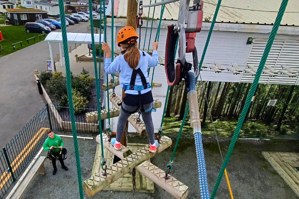 Maria's daughter, Lucy, is taking on the high wires on her holiday at Parkdean. She is securely strapped in whilst an instructor guides her from below.