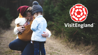 VisitEngland logo overlayed on a family out for a winter walk