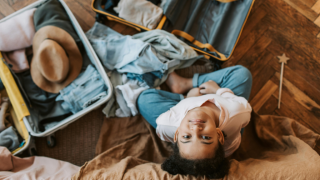 Child surrounded by packed suitcases