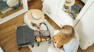 Mother and daughter packing a suitcase