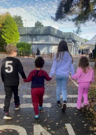 Four children walking holding hands in a caravan park on holiday