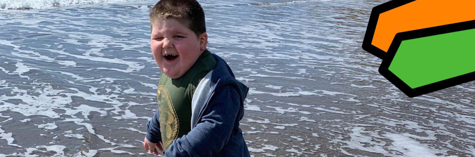 Adrian's son, Jason, is standing in the sea on his holiday, his smiling and excited face is turned toward his dad who is taking the photo