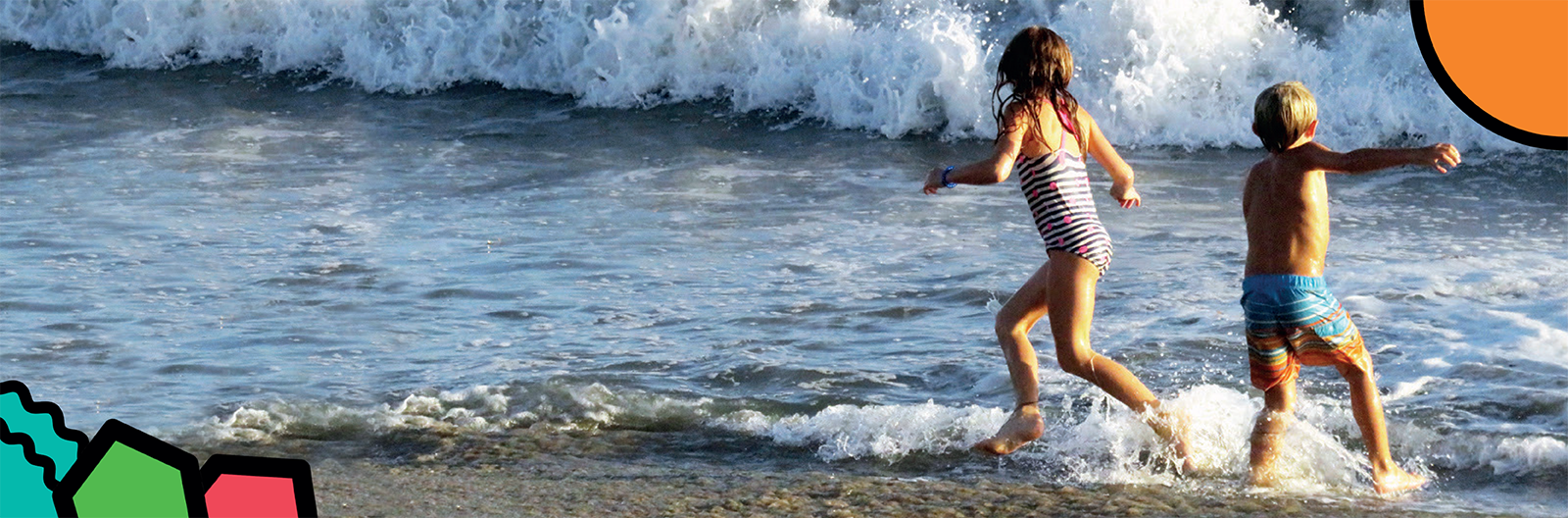 Children run and play in the sea on their family holiday