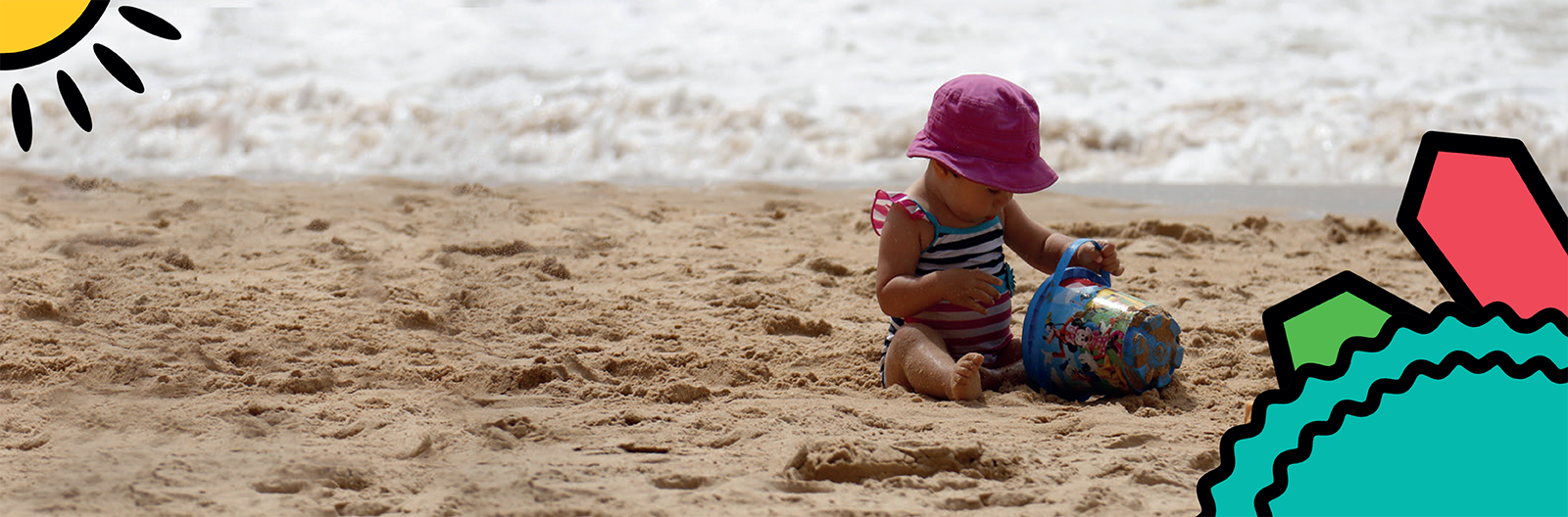 A child plays with a bucket and spade on the beach on a family holiday