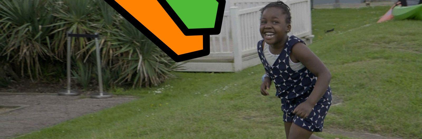 Abi's daughter, Loveina, runs through the green grass of the holiday park with a huge grin on her face on her first family holiday