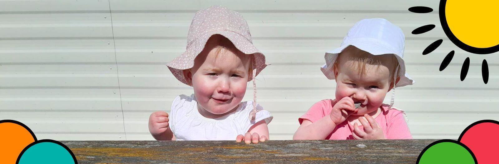 Katy's two daughter were sitting on the bench smiling happily.