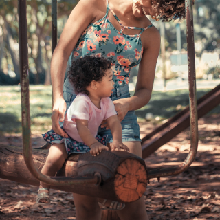 A mother and daughter are playing at a park