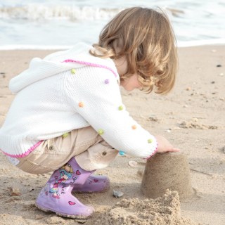A girl is building a sandcastle on the beach