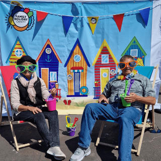 A couple smiling happily in beach chairs.