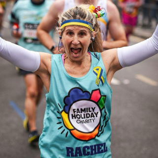woman wearing FHC running top cheering and smiling at the camera.