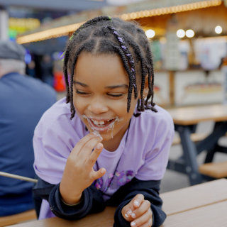A young girl eating marshmallows on her family holiday