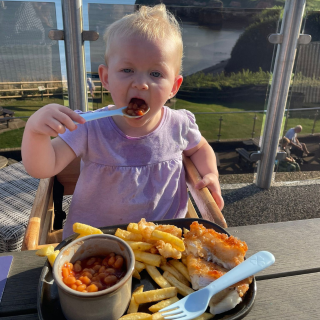 Baby eating beans on holiday