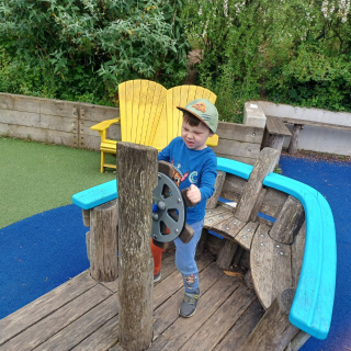 Boy playing on wooden ship in playground