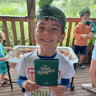 Boy holding up a booklet smiling 
