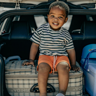 Boy sitting on a suitcase