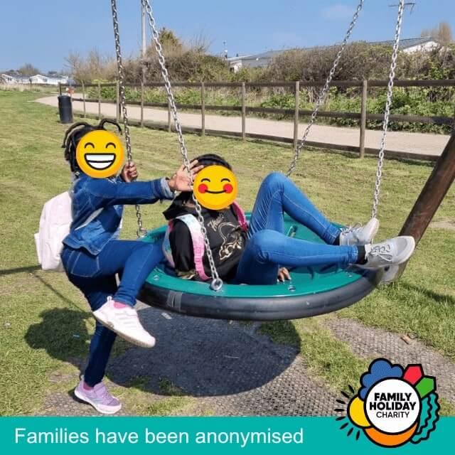 Josephine's daughters play on a swing on their family holiday.