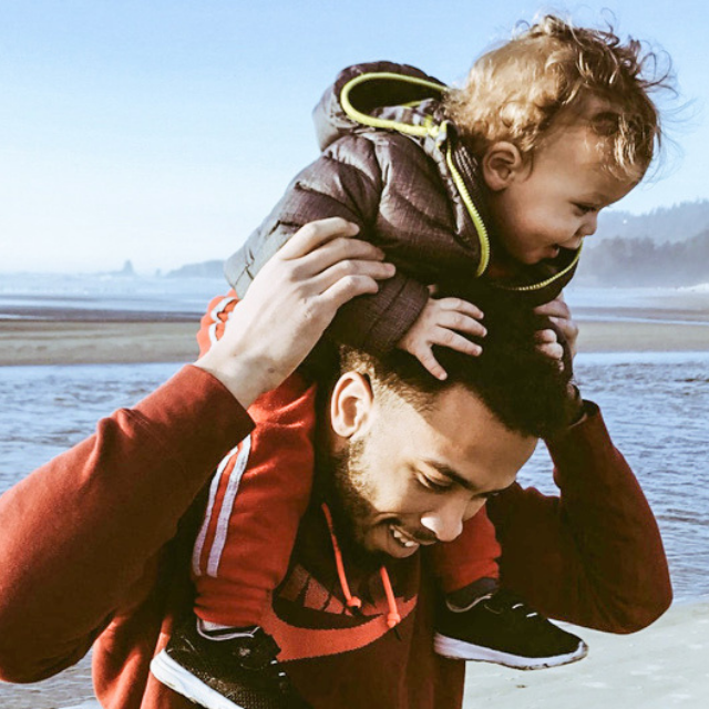 Child on Dad's shoulders at the beach