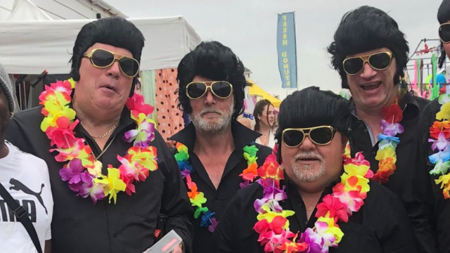 Angela's family stands with a group of 5 people dressed as Elvis on their holiday