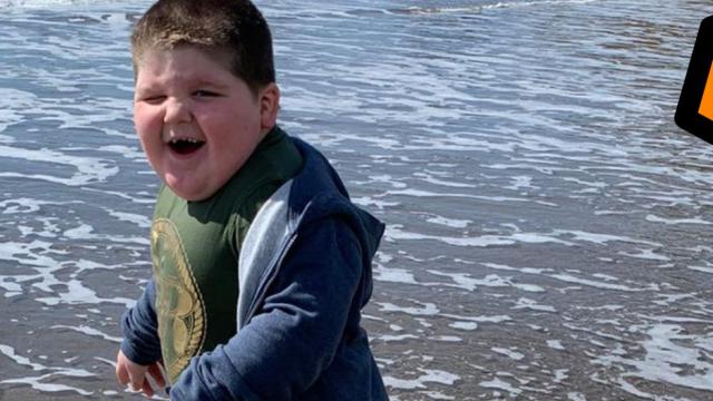Adrian's son, Jason, is standing in the sea on his holiday, his smiling and excited face is turned toward his dad who is taking the photo