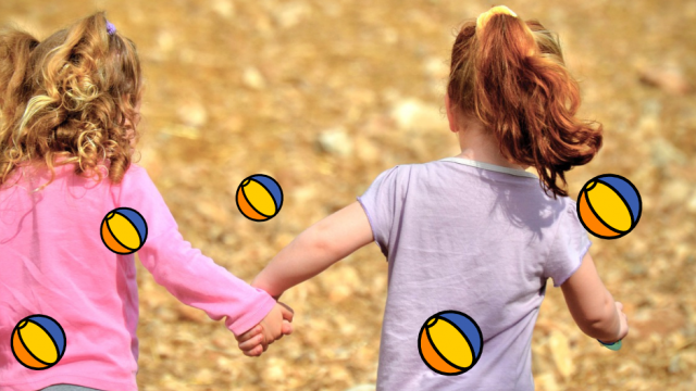 Two girls running through a summer cornfield holding hands